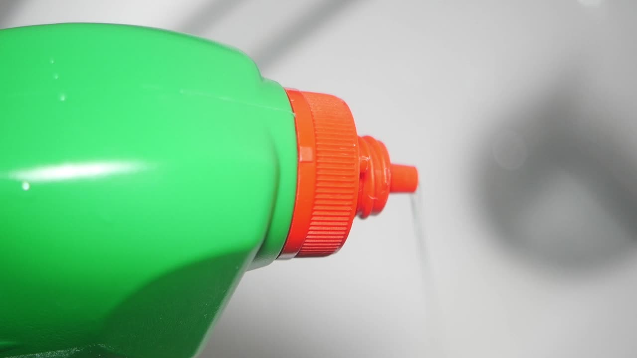 Close-up of a green bottle dispensing liquid
