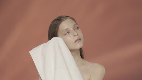woman drying her face with a towel