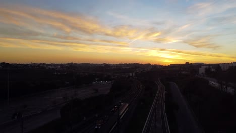 drone shot flying over a train station with an amazing sunset in the background