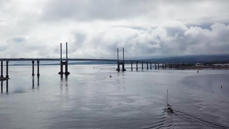 aerial view of kessock bridge with boats in the foreground on a cloudy summer day in scotland.