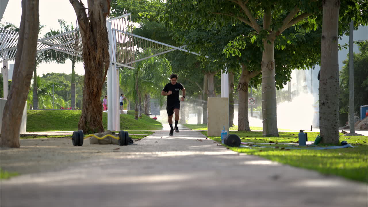 movimiento lento de un atleta masculino latino corriendo hacia la cámara de entrenamiento en el parque