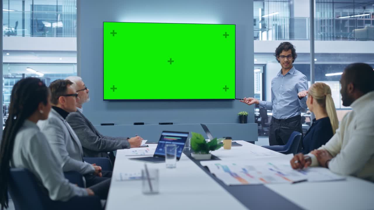 Office Conference Room Meeting Presentation: Charismatic Latin Businessman Talks, Uses Green Screen Chroma Key Wall TV. Successfully Presenting a e-Commerce Product to Group of Multi-Ethnic Investors