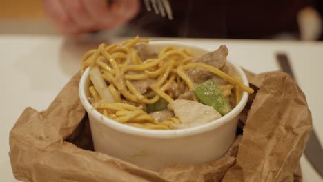 eating take away food: hot, delicious thai green curry noodles