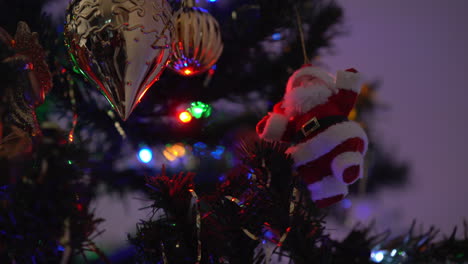 santa claus decoration hanging on a tree with lights