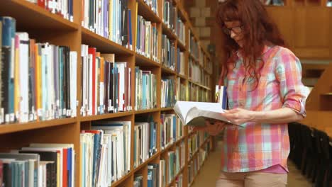 Estudiante-Leyendo-Un-Libro-De-La-Biblioteca