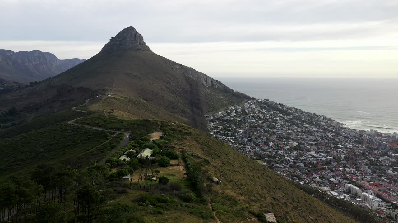 케이프 타운의 신호 언덕 위를 날며 황혼에 사자 머리 봉우리와 해점 지구를 보여줍니다.