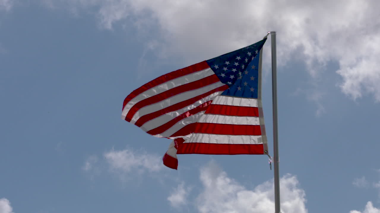 Bandiera americana sventola nella brezza su uno sfondo di cielo blu.