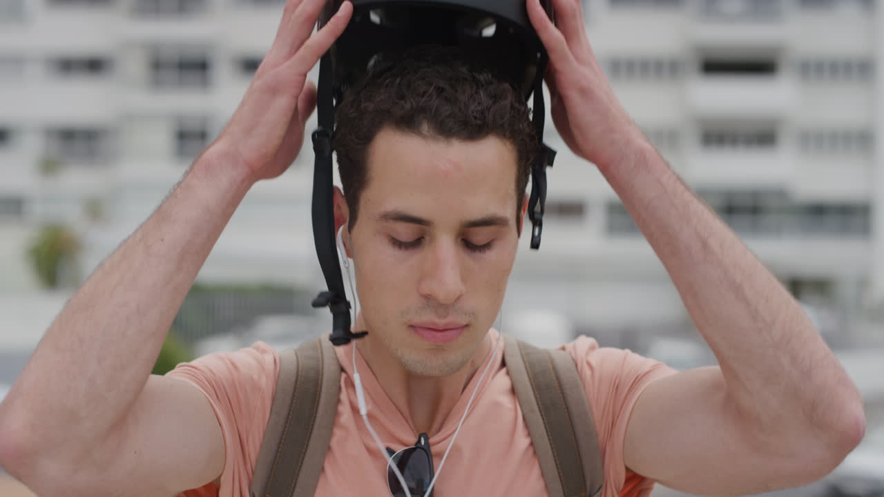 retrato hombre joven se quita el casco buscando serio usando auriculares escuchando música hombre atractivo en la protección de seguridad de la ciudad urbana