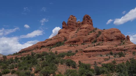 arizona rock formations from a passing car with blue sky and clouds in the background