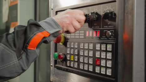 operation of a cnc machine control panel by a skilled worker in a manufacturing setting