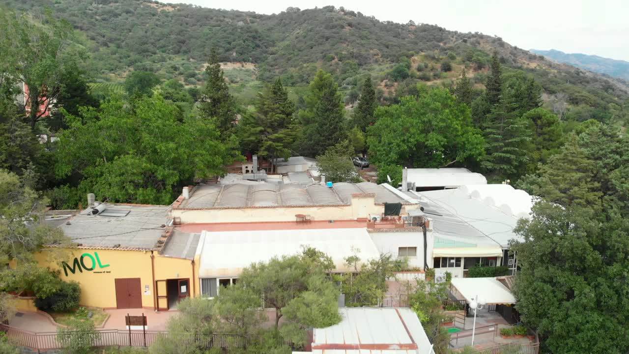 공중: 이탈리아 시칠리아에 있는 작은 집을 드러내는 거대한 시멘트 기둥 위로 드론이 떠오른다