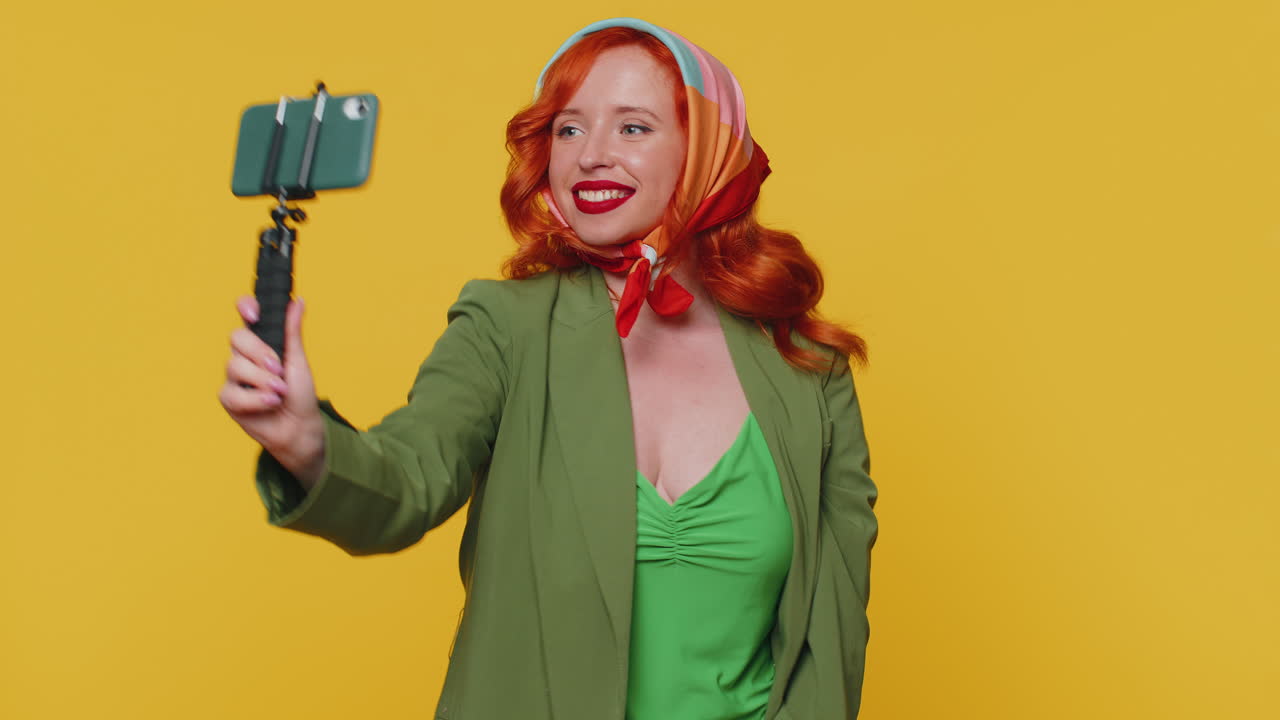 성인 소녀 블로거가 휴대 전화로 셀카를 찍고, 가입자와 온라인으로 비디오 통화를 통신합니다.