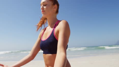 Woman-performing-yoga-at-beach-on-a-sunny-day-4k