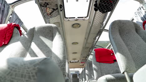 Low-angle-shot-sliding-right-to-left-of-the-interior-of-an-old,-vintage-bus-coach