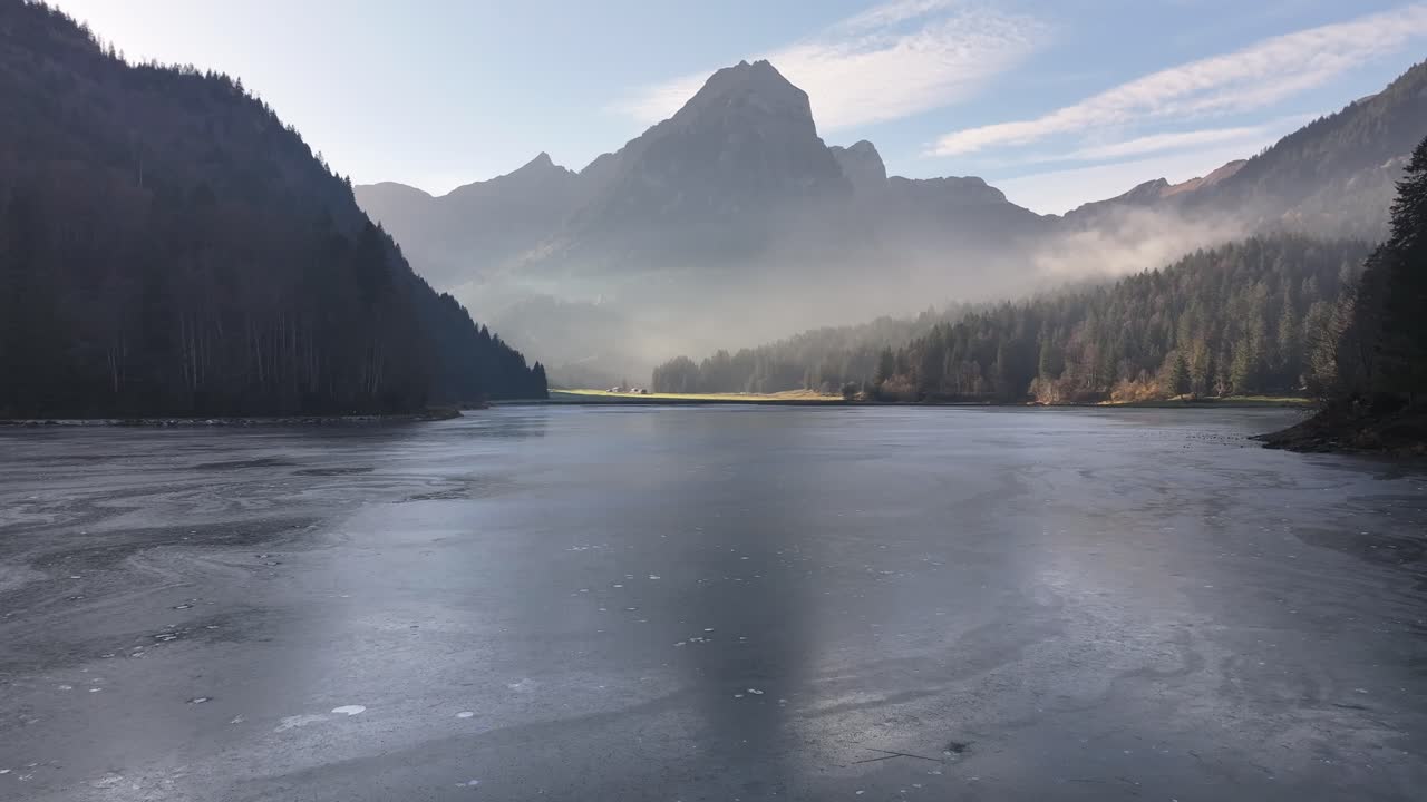 Frossen Obersee med tåkete fjell og skog, Näfels, Glarus, Sveits