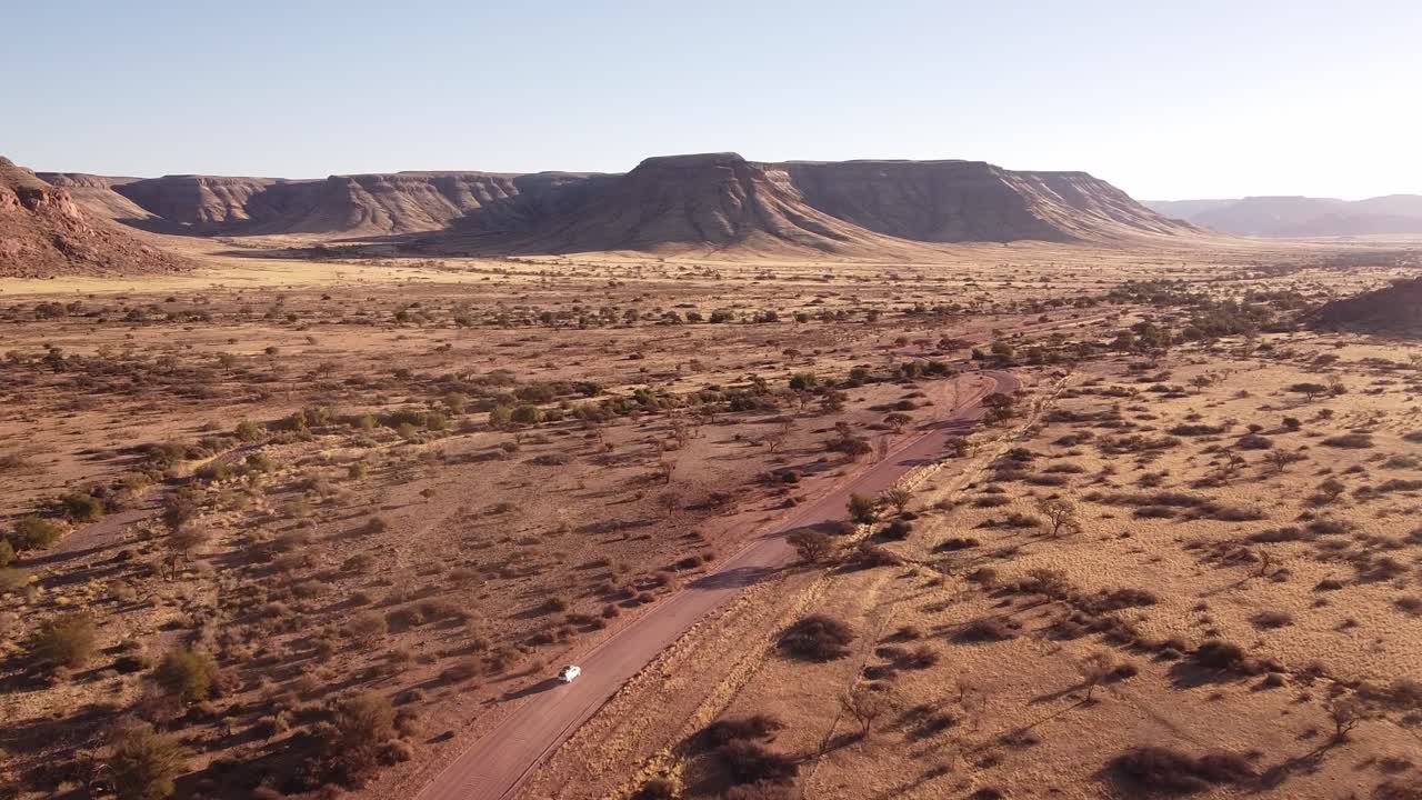 aventura a través de dunas interminables: tomas de drones de 4k de la unidad del desierto en namibia, áfrica con un toyota hilux 4x4 con carpa en el techo