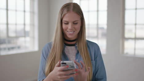 slow-motion-portrait-of-beautiful-young-blonde-woman-in-new-apartment-room-texting-browsing-using-smartphone-mobile-technology-happy-excited