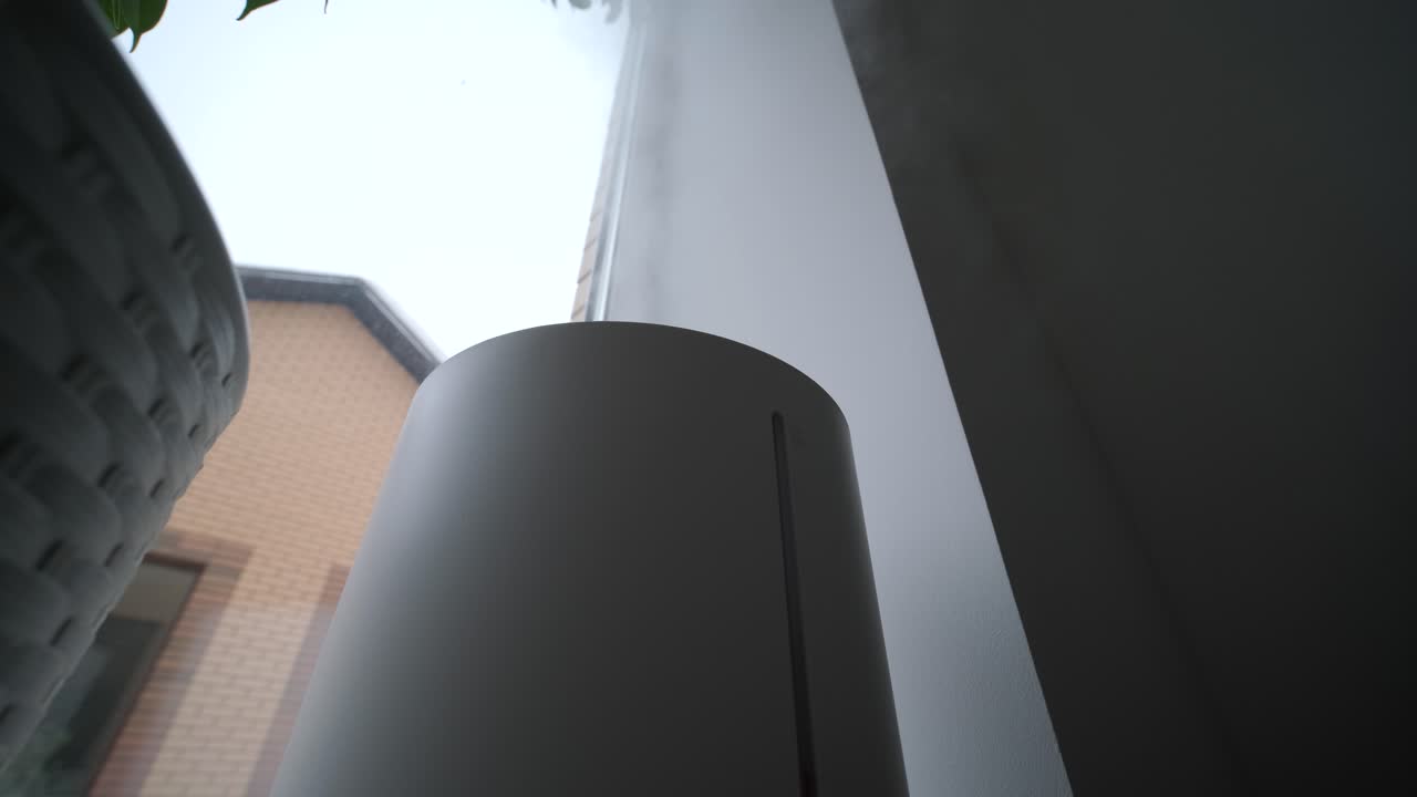 Luftfuktare som avger dimma inomhus nära ett fönster