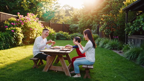 family enjoying pizza together outdoors