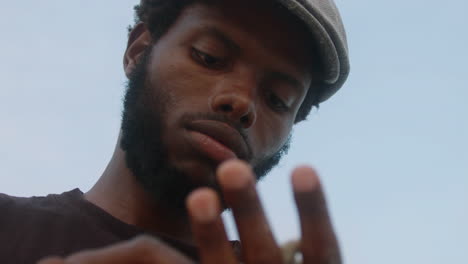 medium close-up of a young black man on an exotic beach with a coral in his hand