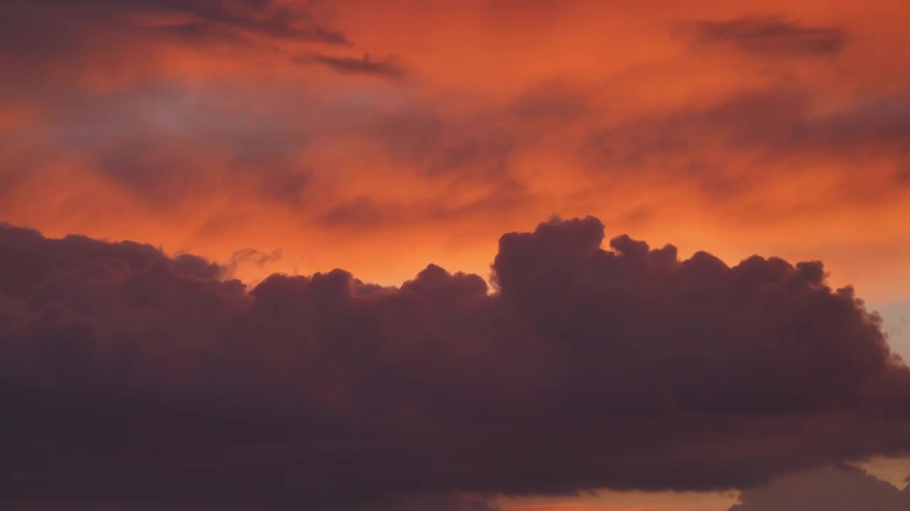 Dramatic Sunset Clouds Moving Across a Vibrant Orange Sky