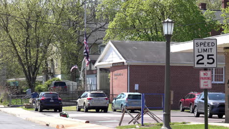 postal customer exits parked car and carries package toward post office building