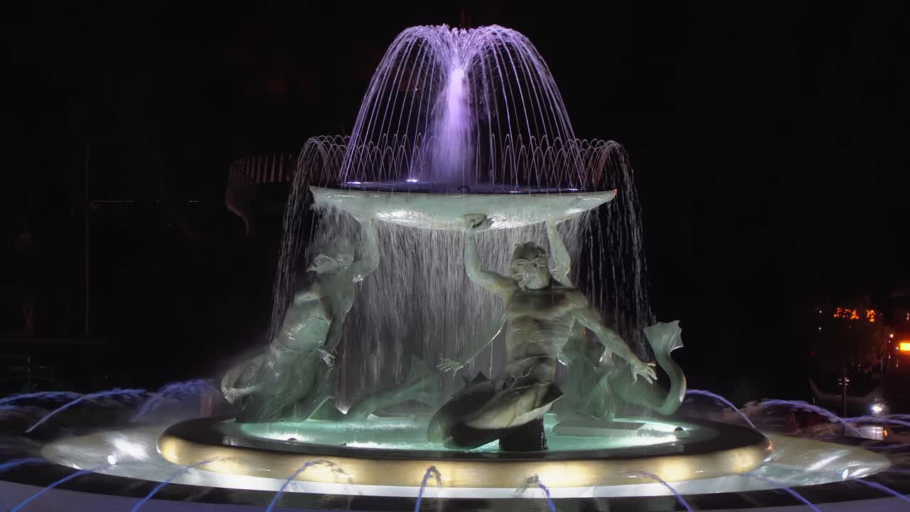 las figuras de la fuente iluminada de tritón representan las tres esculturas del mar de los dioses mirando a la puerta de la ciudad de valletta en malta.