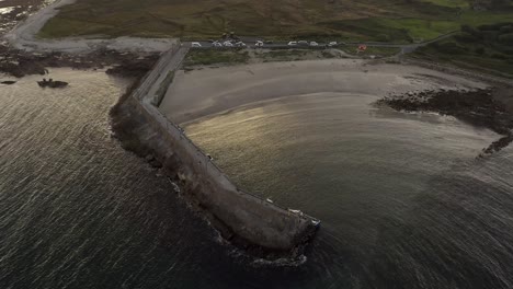 aerial view of spiddal beach and pier bathed in stunning sunset light