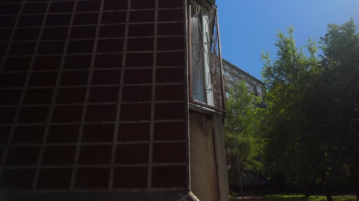 Fluttuando attraverso un sobborgo baltico con appartamenti in cemento e balconi e finestre sovrapposti