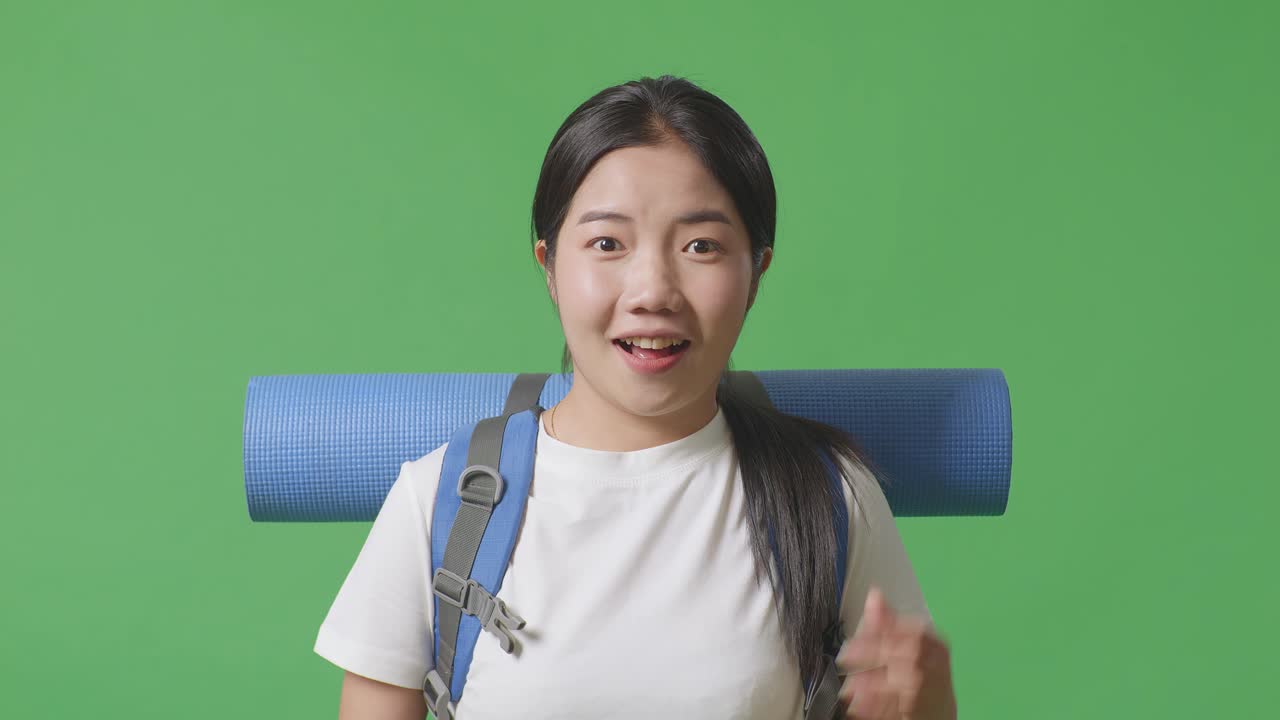 mujer con mochila y estera de yoga en la pantalla verde