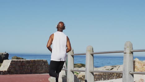 Senior-african-american-man-exercising-running-on-road-by-the-sea