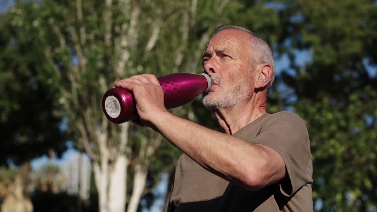 hombre mayor bebiendo agua al aire libre
