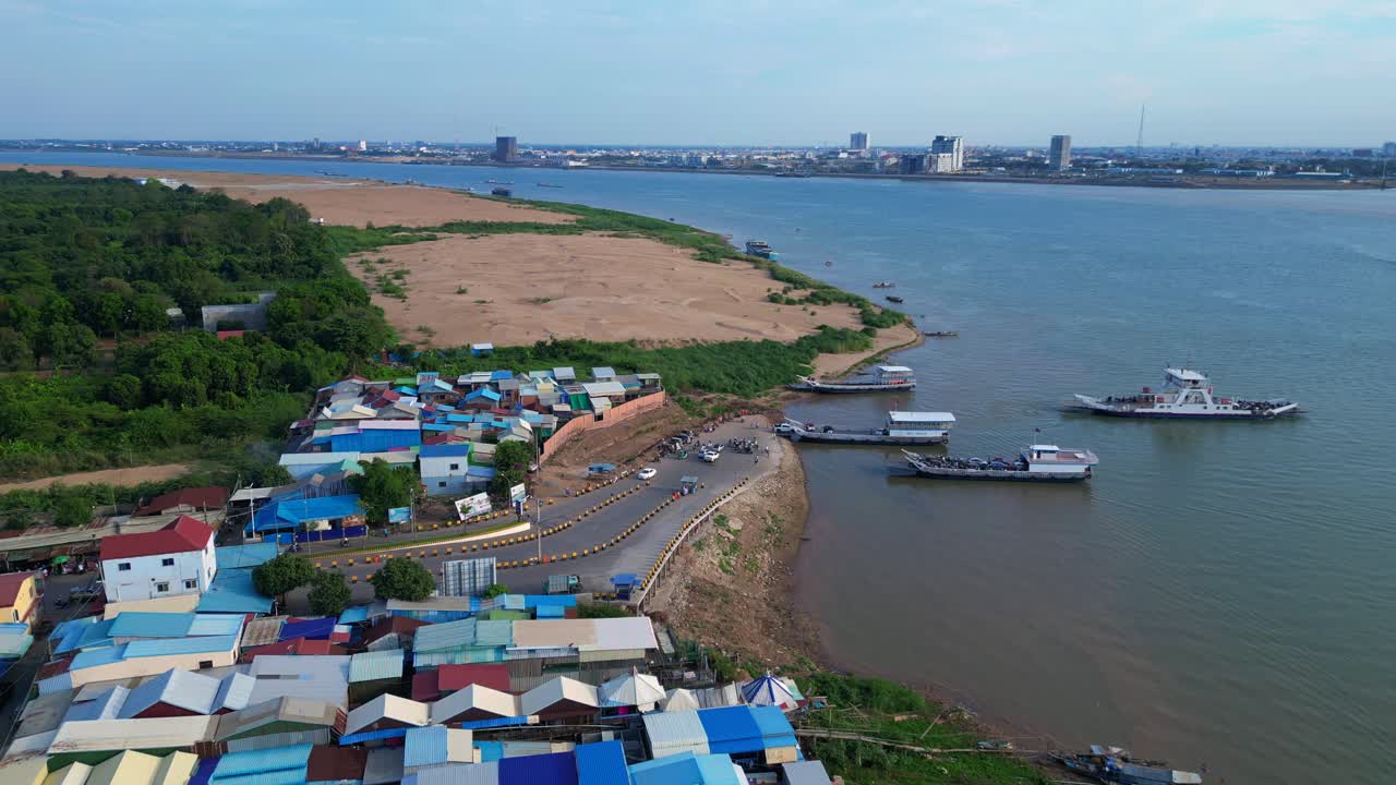 fishing village with colorful shacks along the Mekong river in Cambodia, a developing country in Southeast Asia. Majestic aerial view flight static tripod hovering drone