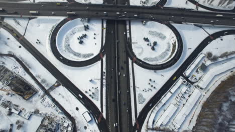 Top-view-car-traffic-freeway-overpass.-Cars-moving-on-snowy-highway-intersection