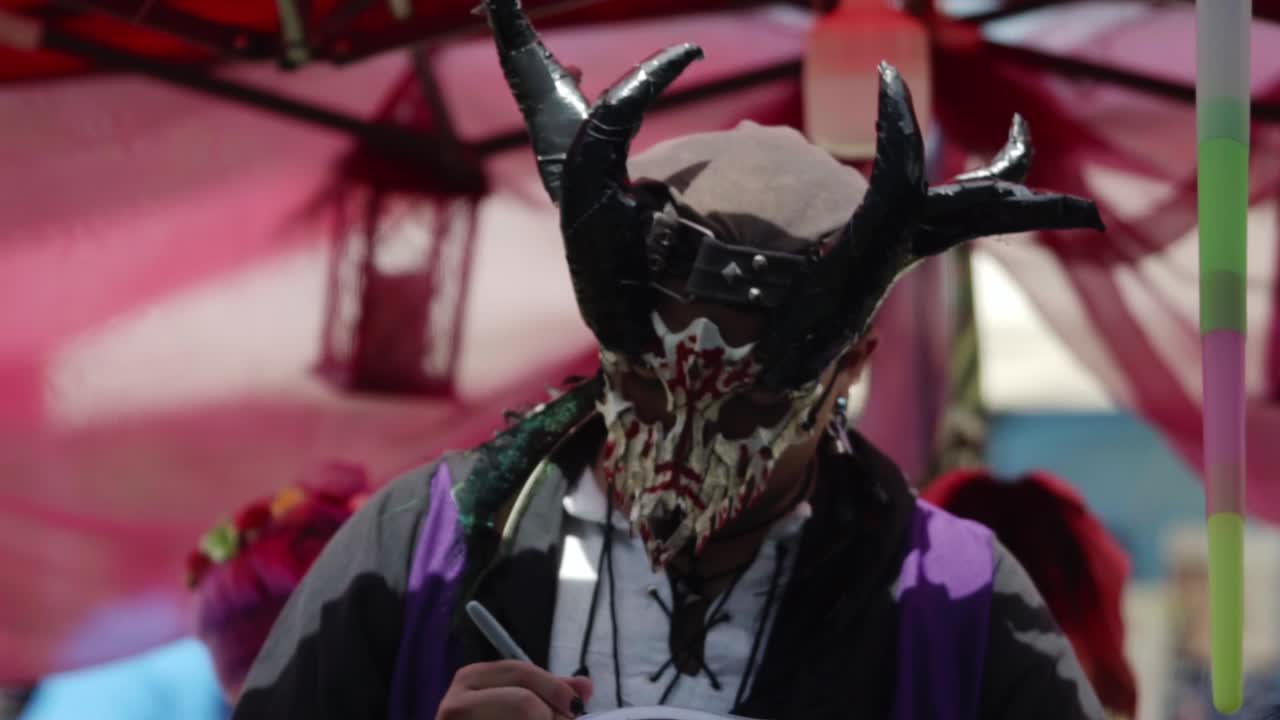 Close-up of an ornate grotesque mask and detailed costume worn by a medieval reenactor