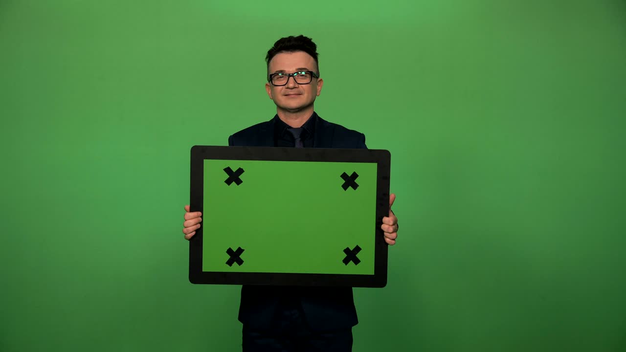 Empresário confiante e sorridente segurando placa de chromakey.