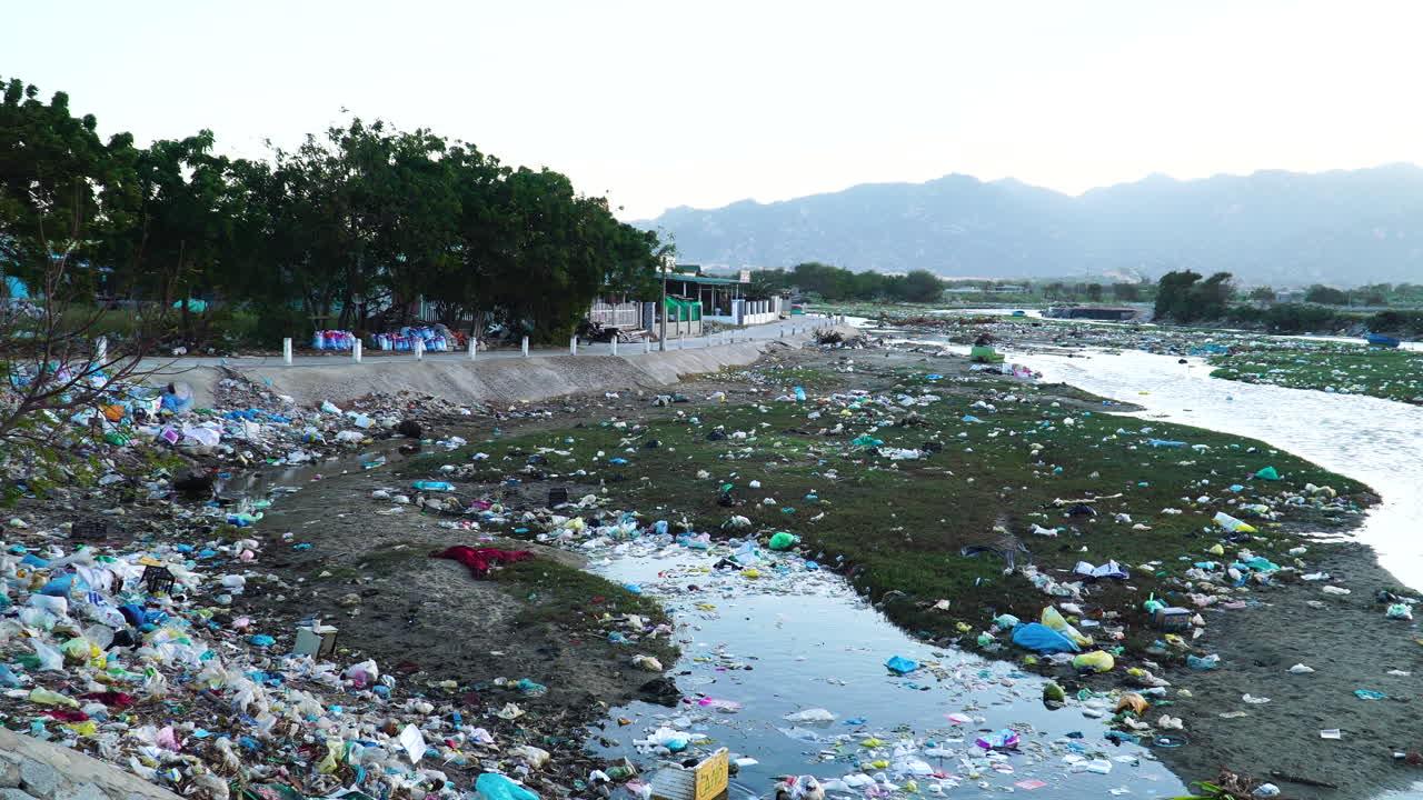 toma estática de basura esparcida a orillas del río