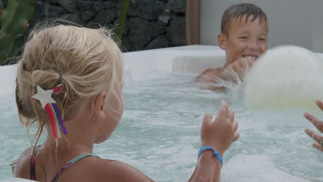 El-Día-Está-Lleno-De-Diversión,-Hermano-Con-Hermana-Pequeña-Jugando-A-La-Pelota-En-El-Jacuzzi.