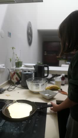young girl making pancakes