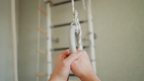 스포츠 벽에 체조 링을 잡고 따뜻해지는 사람의 1인칭 시각, 손과 링 초점