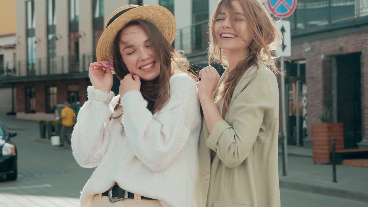 dos mujeres jóvenes posando en una calle de la ciudad