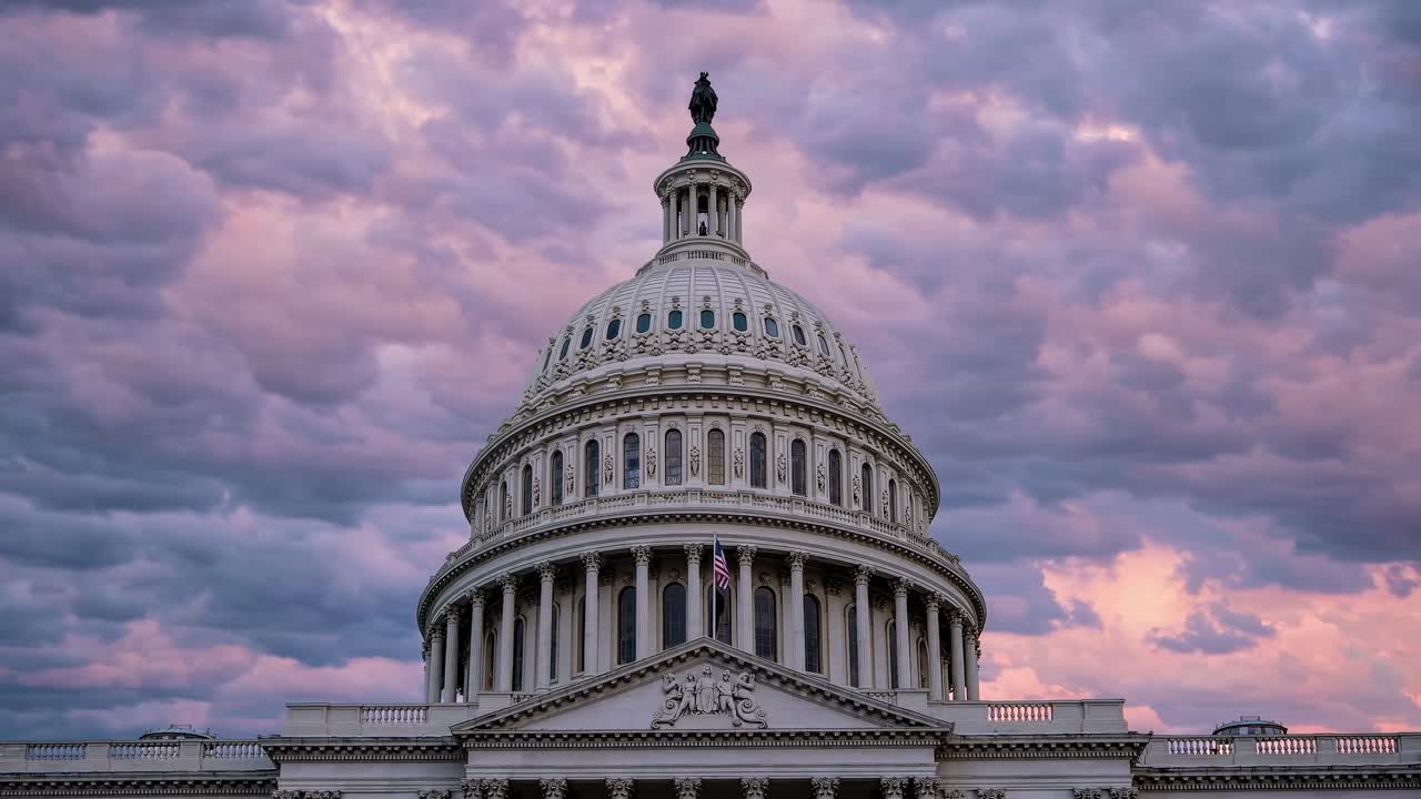 Dramatic low-angle video shot of the Capitol dome against a vibrant, cloudy sunset sky