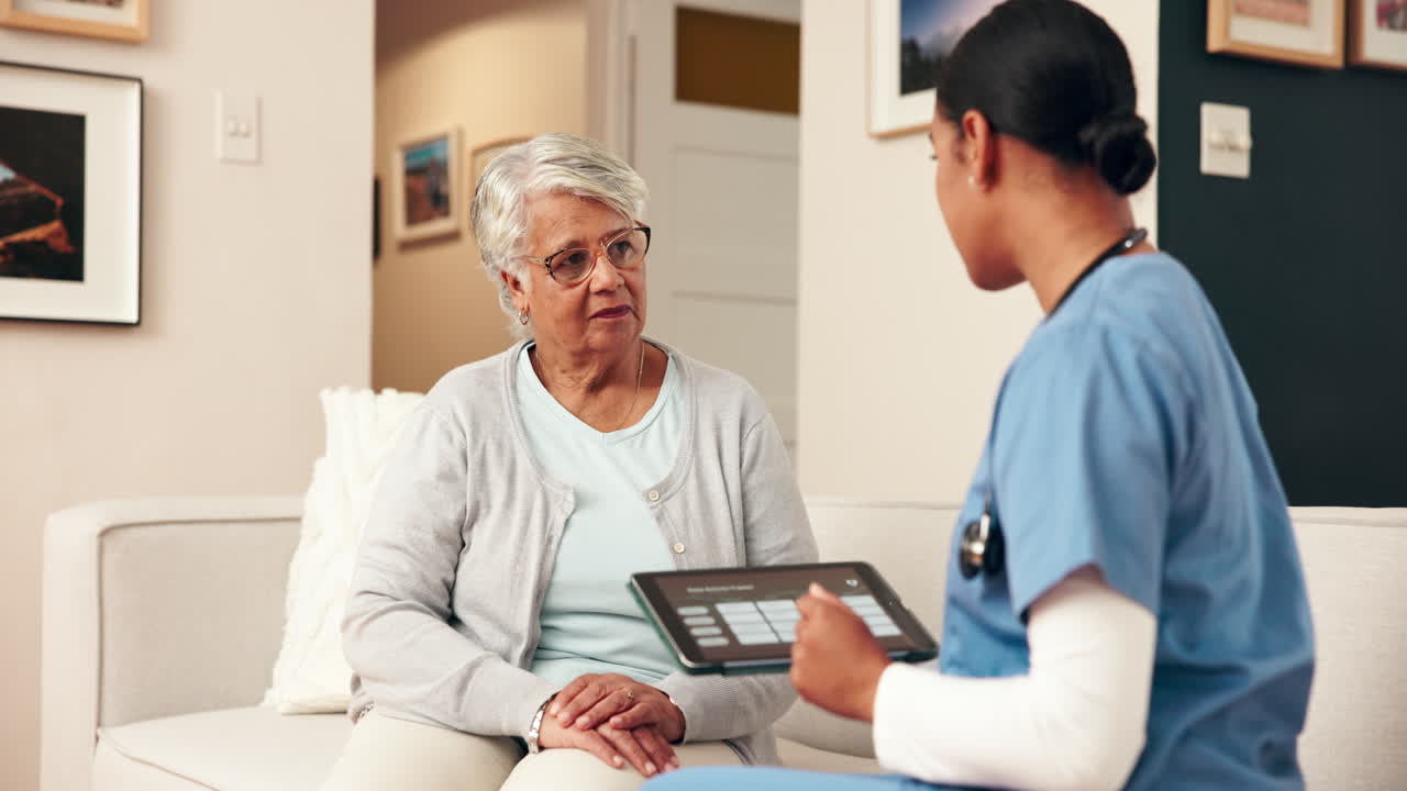 A nurse consults with a senior woman at home