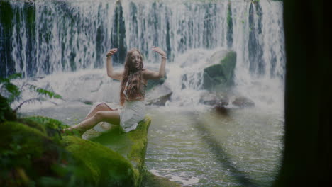 portrait of a beautiful woman relaxing in front of a waterfall