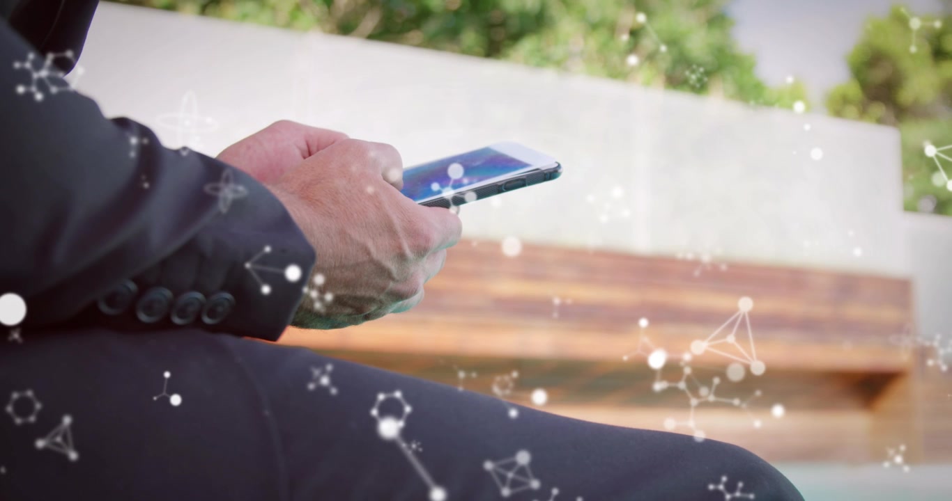 Animation of molecules over caucasian businessman using smartphone