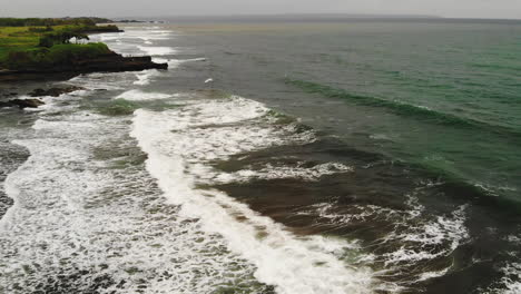 aerial footage of big stormy ocean waves splashing on a tropical asian island