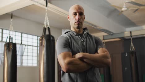 portrait of fit caucasian man with arms crossed at the gym