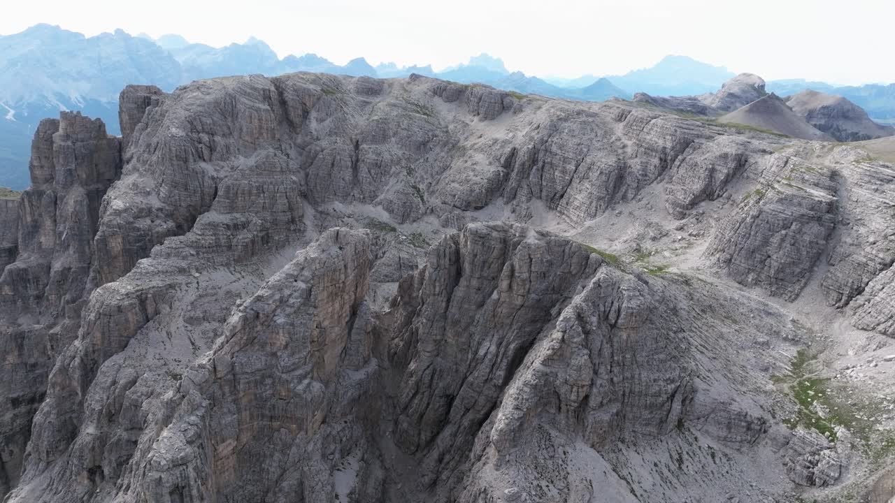 Aerial view of Dolomites' rugged limestone peaks, deep gorges, and scattered vegetation