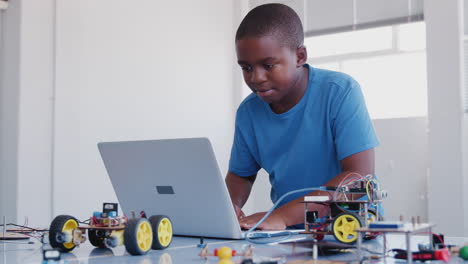 Male Student Building And Programing Robot Vehicle In After School Computer Coding Class