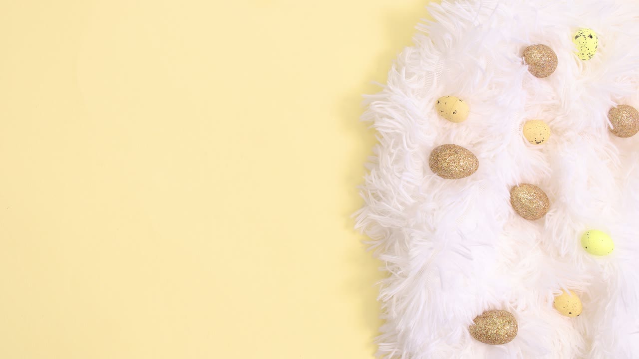 Easter white and gold decoration and paper card note appear on bright yellow background. Stop motion flat lay